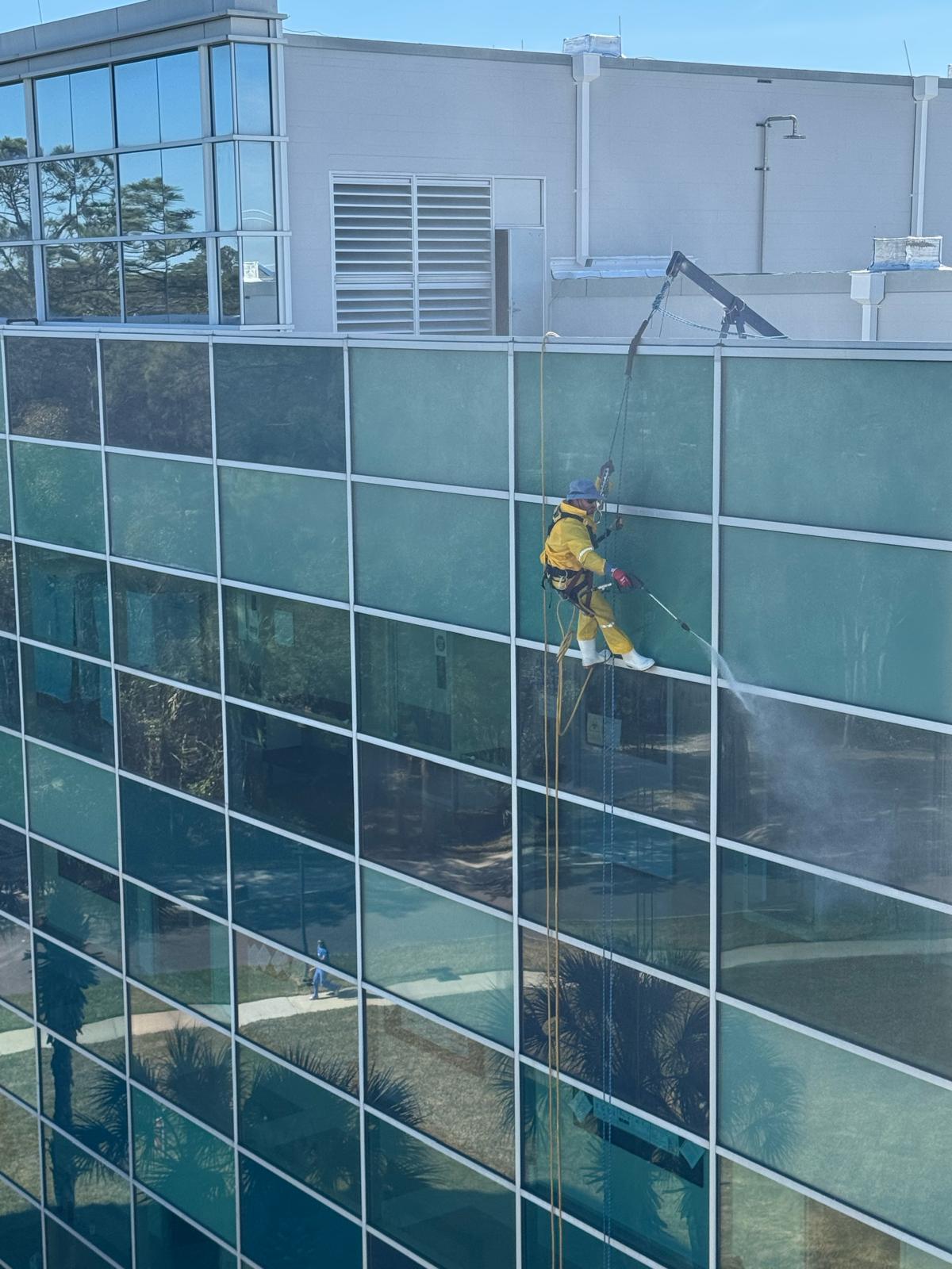 Rope access pressure washing on high-rise building